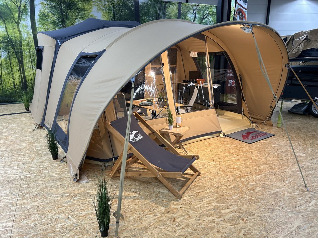 Cabanon-Zeltanhänger mit Sonnensegel und Sitzbereich in der Ausstellung von TF-Freizeitfahrzeuge